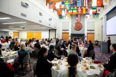 A group of people in a large room eating dinner